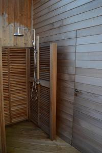 a bathroom with a shower in a wooden wall at Villa 1 in Saint-Jacut-de-la-Mer