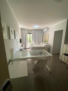 a large room with a bed and a glass table at Flat Avenida Paulista - Trianon in São Paulo