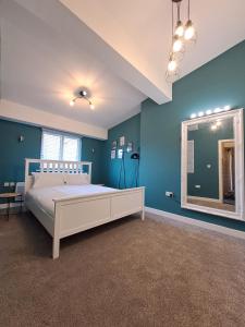 a bedroom with a white bed and blue walls at Harrington Suite in Liverpool