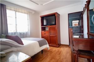 波哥大的住宿－Hotel Virrey Central，一间卧室配有一张床和一台平面电视