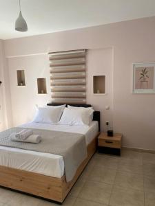 ein Schlafzimmer mit einem großen Bett mit weißen Kissen in der Unterkunft Keskos Luxury Villa in Artemida