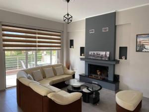 a living room with a couch and a fireplace at Keskos Luxury Villa in Artemida