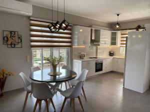 a kitchen with a dining room table and chairs at Keskos Luxury Villa in Artemida
