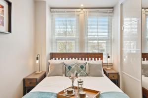 Llit o llits en una habitació de Stylish 2 Bed, Business & Leisure. Wifi and private garden; by First Serve - West Wimbledon
