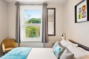 เตียงในห้องที่ Stylish 2 Bed, Business & Leisure. Wifi and private garden; by First Serve - West Wimbledon