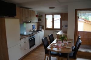 a kitchen with a table and chairs and a kitchen with a table and a table at Ferienhof Eger in Immenstadt im Allgäu