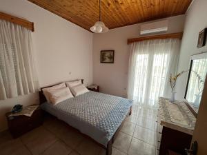a bedroom with a bed in a room with windows at Villa Lazaros 