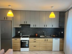 - une cuisine avec des appareils électroménagers blancs et 2 lumières jaunes dans l'établissement Apartament Zlota Jesień 2C, à Cracovie 8 autres photos