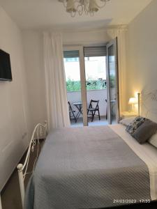 1 dormitorio con cama y vistas a un balcón en Alba b&b, en Polignano a Mare