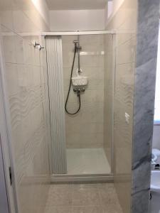 een douche met een glazen deur in de badkamer bij Delos e Artemide in Siracusa
