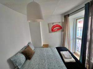 a bedroom with a bed with a red lips on the wall at Cosy Mouraria Rooms in Lisbon