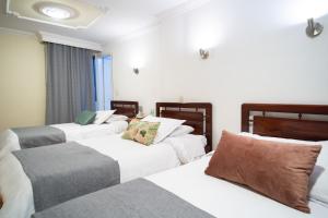 波哥大的住宿－Hotel Virrey Central，酒店客房设有三张床和窗户。