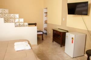 a small room with a refrigerator and a tv at Pousada Chácara Maria da Graça in Tremembé