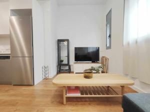 a living room with a table and a refrigerator at Mazi Apartments Loft in Mataró