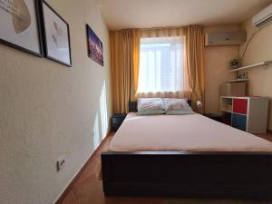 mały pokój z łóżkiem z oknem w obiekcie Sinemorets apartment w mieście Sinemorec