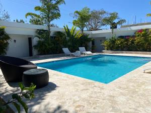 a swimming pool with chairs next to a house at The White Rock Hotel B&B in Los Conucos