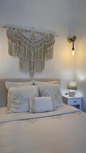 - un lit avec des oreillers blancs et un rideau au-dessus dans l'établissement Insolite : Gîte Namaste à 500m à pied du Zoo de Beauval, à Seigy