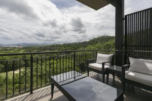 balcone con 2 sedie e tavolo con vista di Roble Sabana 304 Luxury Apartment - Reserva Conchal a Playa Conchal