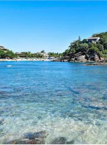 a large body of water with a beach in the background at Búzius na Praia da Ferradura Frente mar in Buzios