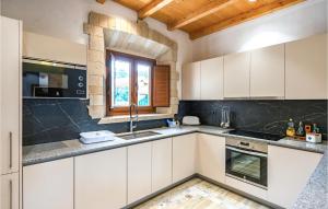 a kitchen with white cabinets and a window at Lovely Home In Vilademuls With Swimming Pool in Vilademuls