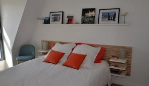 a bedroom with a white bed with red pillows at LES AUGUSTINS, chambres d'hôtes, quartier historique, accueil 2 roues in Angers