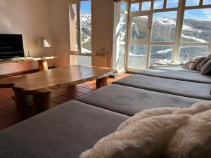 a room with three beds and a table and a view of a mountain at Arrayanes Royal in Sierra Nevada