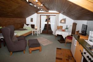 ein Wohnzimmer mit einem Bett und ein Zimmer mit einem TV in der Unterkunft Haus St. Korbinian in Mittenwald