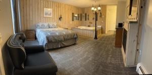 a hotel room with a bed and a bath tub at Vacationland Inn & Suites in Brewer