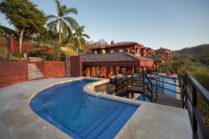 a house with a swimming pool in front of a house at Bougainvillea 5306 Luxury Apartment - Reserva Conchal in Playa Conchal