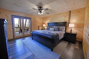 1 dormitorio con 1 cama y ventilador de techo en Fox Den - Amazing cabin, view, hot tub and more!, en Blue Ridge
