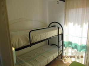 a small bedroom with a bunk bed and a window at Sardegna Stupenda N 01 in Aglientu +20 photos