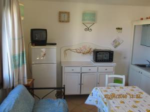 a living room with a kitchen with a microwave and a microwave at Sardegna Stupenda N 01 in Aglientu