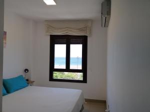 sypialnia z łóżkiem i oknem z widokiem na ocean w obiekcie The Apartment w mieście Gran Tarajal