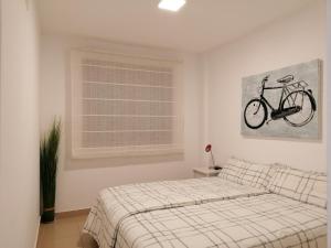 グラン・タラハルにあるThe Apartmentのベッドルーム1室(ベッド1台付)が備わります。壁に自転車の写真が飾られています。