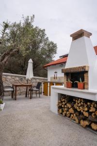 une cour avec un foyer extérieur, une table et des chaises dans l'établissement CASA DI'ELEN, à Faliraki