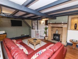 sala de estar con sofá rojo y chimenea en Cholmley Cottage, en Whitby