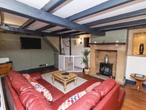 a living room with a red couch and a fireplace at Cholmley Cottage in Whitby