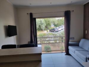 a living room with a couch and a view of a parking lot at Studio climatisée dans résidence à 5 minutes des plages a pied in Propriano