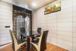 a dining room with a glass table and chairs at Hotel Grand Shiva Haridwar in Haridwār