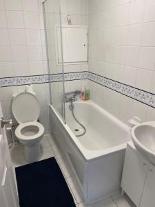La salle de bains est pourvue d'une baignoire, de toilettes et d'un lavabo. dans l'établissement Great Location 4 bedroom, à Londres