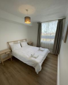 - une chambre avec un lit blanc et une fenêtre dans l'établissement Great Location 4 bedroom, à Londres