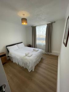 - une chambre avec un lit blanc et une fenêtre dans l'établissement Great Location 4 bedroom, à Londres