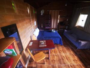Sala de estar con cama y mesa en Chalé Astral, en Alto Paraíso de Goiás