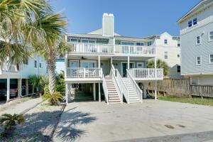 a large house with stairs leading up to it at Condo with 2 Decks - Steps to Wrightsville Beach! in Wrightsville Beach