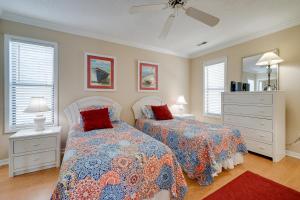 a bedroom with two beds and a mirror at Condo with 2 Decks - Steps to Wrightsville Beach! in Wrightsville Beach