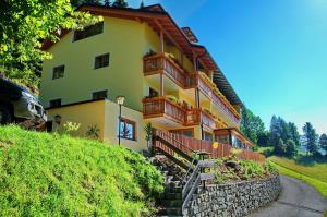 una casa amarilla con una escalera que conduce a ella en Hotel Raunig en Bad Kleinkirchheim