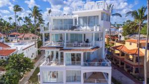 an aerial view of a white building with palm trees at Beachfront Punta Cana Condo for Rent - Ocean View, Private Terrace, and BBQ in Punta Cana +69 photos