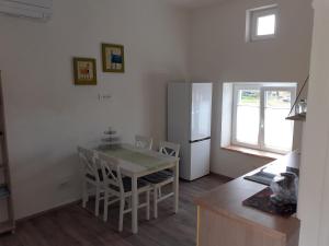 a kitchen with a table and a white refrigerator at Apartment Vignole in Portorož