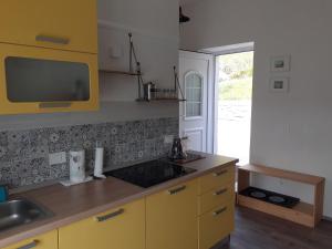 una cocina con armarios amarillos y fregadero en Apartment Vignole, en Portorož