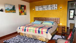 1 dormitorio con 1 cama con una manta colorida en Finca Renacer, en Tibaná